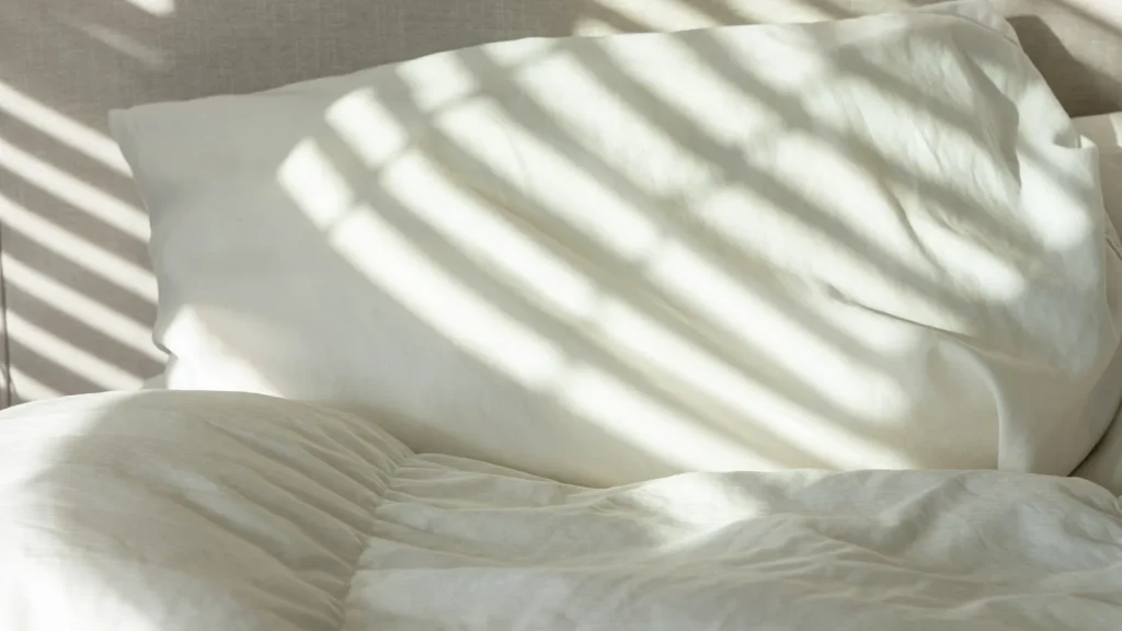 Draps et taies en coton blanc éclairés par la lumière du matin